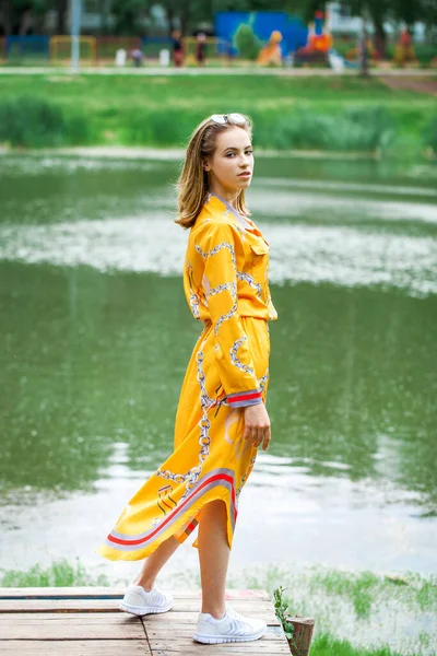 Göl kenarında poz veren sarışın güzel bir kızın vücut portresi.