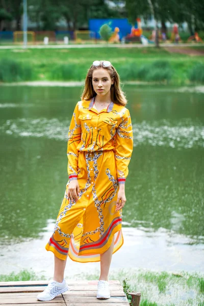 Göl kenarında poz veren sarışın güzel bir kızın vücut portresi.