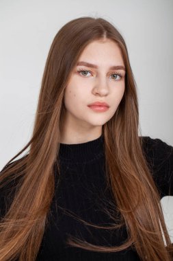 Gri arka planda izole edilmiş güzel esmer bir modelin yakın portresi.