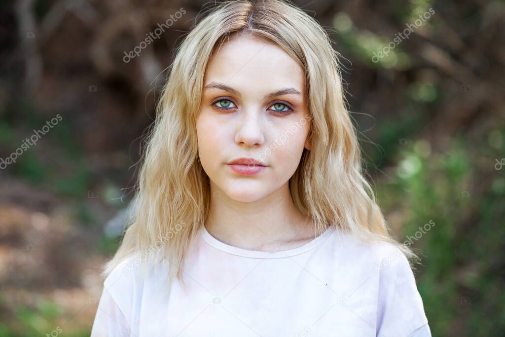 Close up portrait of a young beautiful blonde woman, summer outdoors