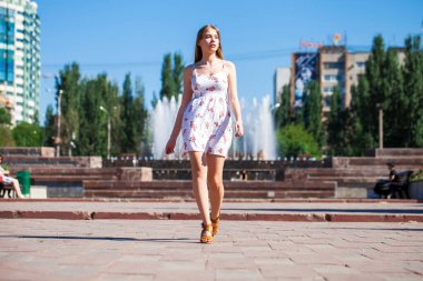 Beyaz elbiseli güzel sarışın bir kızın vücut portresi. 