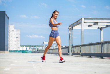 Mavi mayo giymiş güzel bir esmer kızın portresi mavi gökyüzünün arka planında