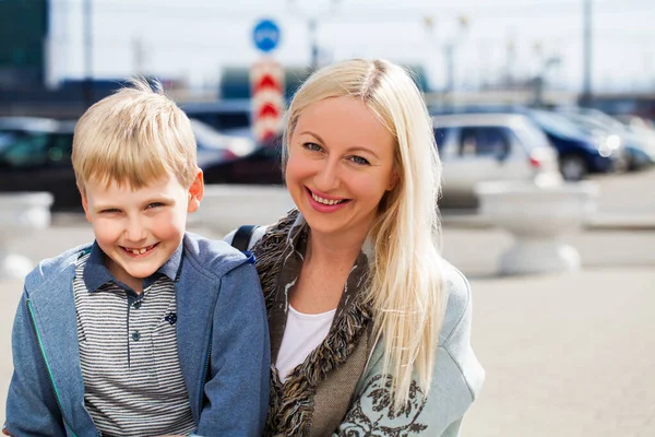 Street portrait of young beautiful mom and blonde son