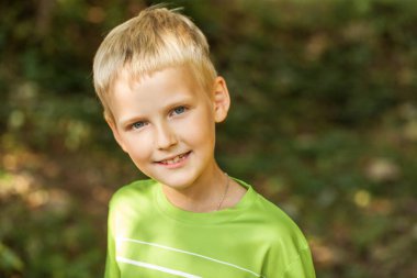 Bir yaz parkındaki küçük bir çocuğun yakın plan portresi.