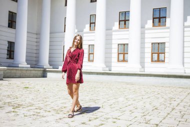 Burgundy elbiseli güzel bir kızın uzun bir portresi. 