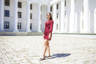 Burgundy elbiseli güzel bir kızın uzun bir portresi. 