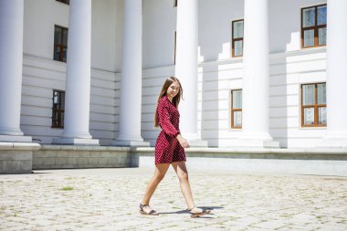 Burgundy elbiseli güzel bir kızın uzun bir portresi. 