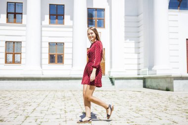 Burgundy elbiseli güzel bir kızın uzun bir portresi. 