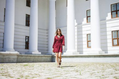 Burgundy elbiseli güzel bir kızın uzun bir portresi. 