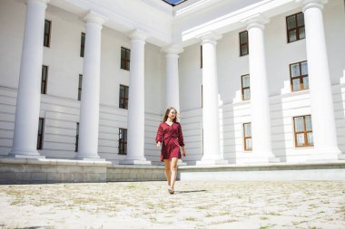 Burgundy elbiseli güzel bir kızın uzun bir portresi. 