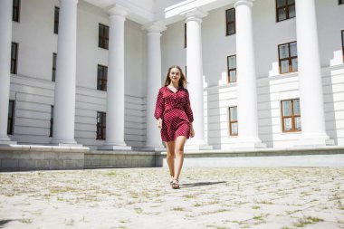 Burgundy elbiseli güzel bir kızın uzun bir portresi. 