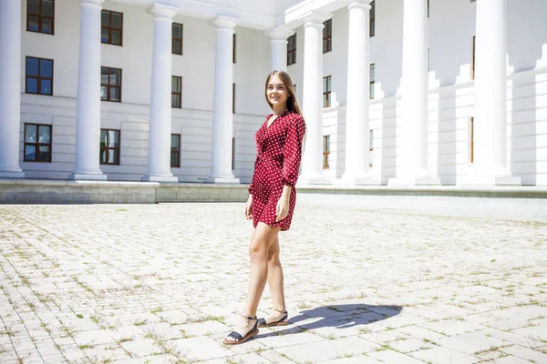 Burgundy elbiseli güzel bir kızın uzun bir portresi. 