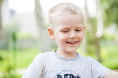 Bir yaz parkındaki küçük bir çocuğun yakın plan portresi.