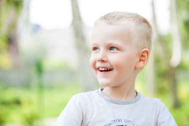 Bir yaz parkındaki küçük bir çocuğun yakın plan portresi.