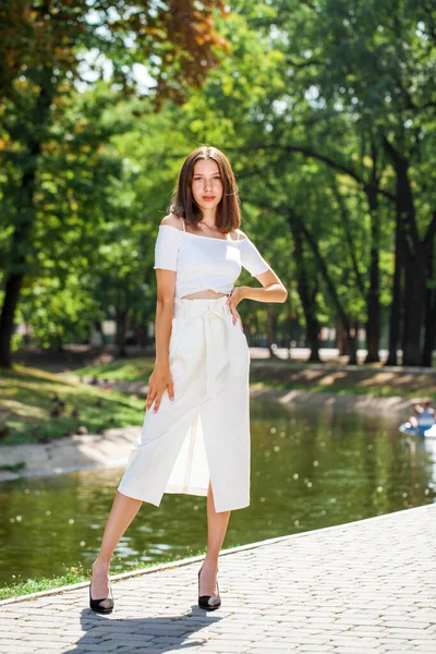 全長の肖像画 夏の公園でポーズをとる白いスカートの若い美しい女の子 — ストック写真