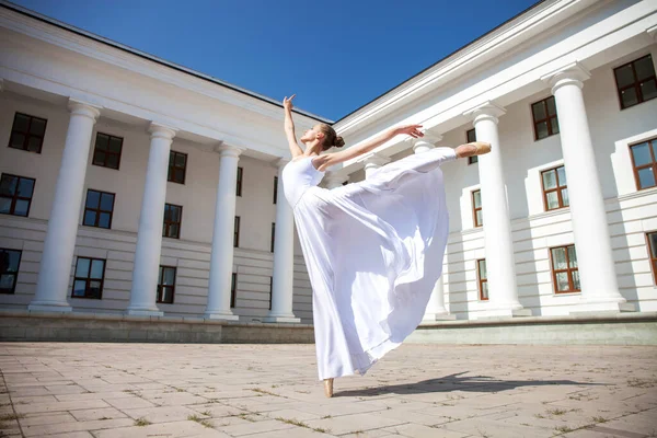 Dancer in a long white skirt dancing on the background of the theater