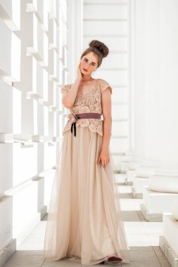 Sokakta poz veren bej elbiseli güzel bir esmer.