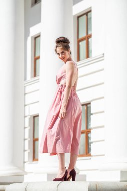 Sokakta poz veren bej elbiseli güzel bir esmer.