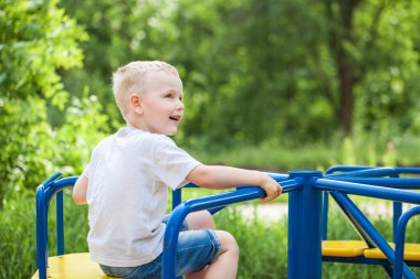 Bir yaz parkındaki küçük bir çocuğun yakın plan portresi.