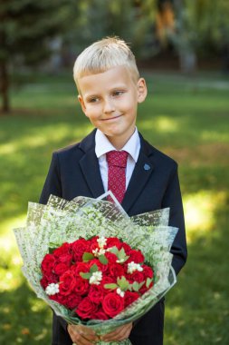 Birinci sınıf öğrencisi, okul üniformalı yakışıklı bir çocuğun portresi.