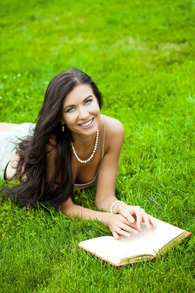 Jeune belle fille lisant un livre en plein air — Photo