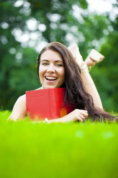 Jeune belle fille lisant un livre en plein air — Photo