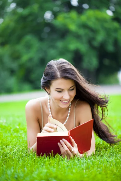 Jovem menina bonita lendo um livro ao ar livre — Fotografia de Stock