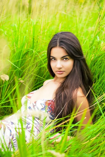 Jonge vrouw rusten en de dag liggen op groen gras — Stockfoto