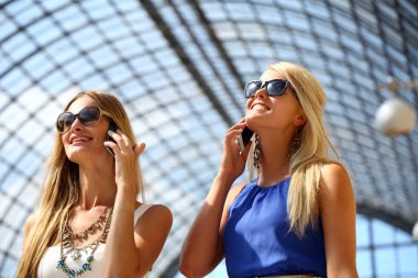 Bununla birlikte güneş gözlüklü bir smartphone ile fotoğraf çekmek iki kız