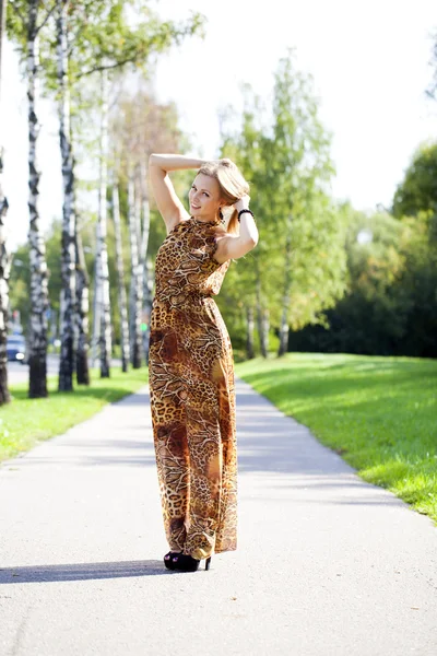 Loira bonita em leopardo impressão vestido longo — Fotografia de Stock