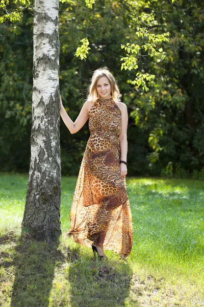 Schöne Blondine im langen Kleid mit Leopardenmuster — Stockfoto