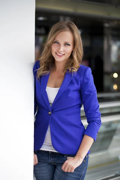 Schöne junge Blondine in einer blauen Jacke — Stockfoto