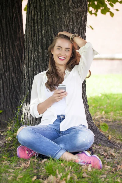 Belle jeune femme lisant un message au téléphone — Photo