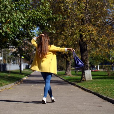 mutlu bir kadın sarı montlu sonbahar street yürüyüş