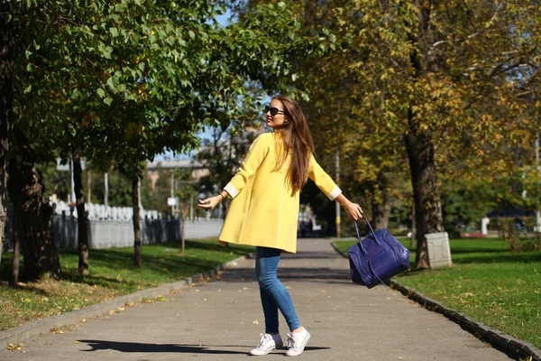 Szczęśliwa kobieta w żółty płaszcz ulicy walking street jesień — Zdjęcie stockowe