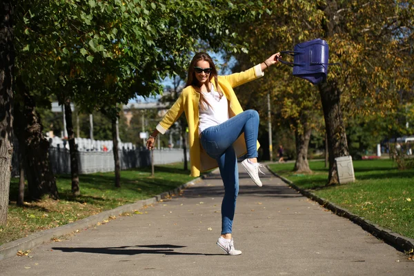 Mujer feliz en abrigo amarillo caminando calle otoño —  Fotos de Stock