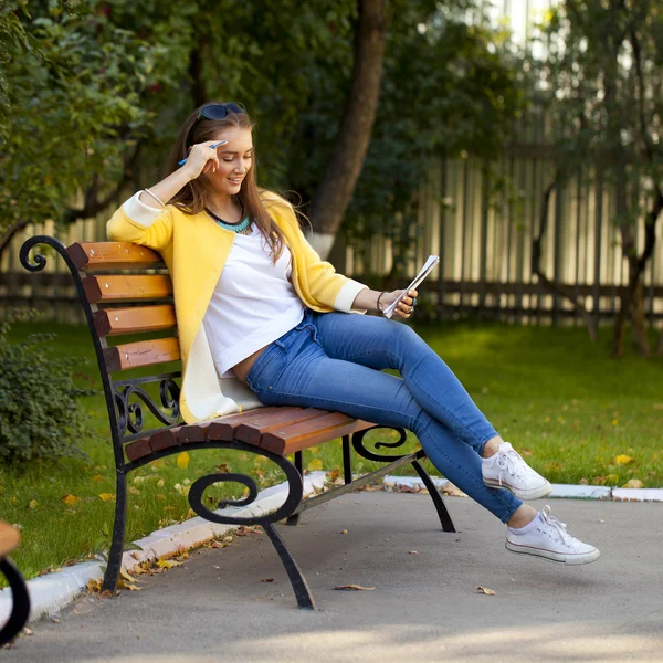 Beautiful young woman in yellow coat — Stock Photo, Image