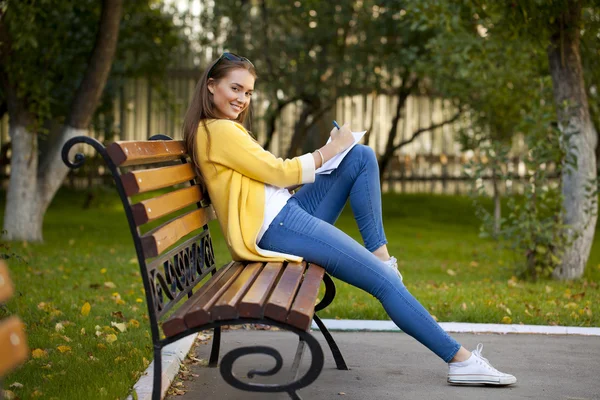 Schöne junge Frau im gelben Mantel — Stockfoto