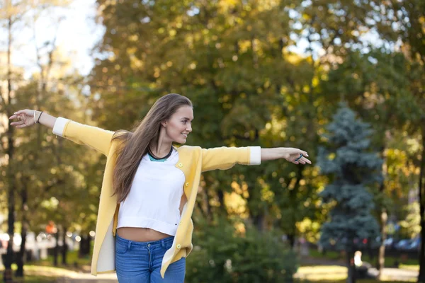 Glad ung kvinna i gul jacka på hösten gatan — Stockfoto