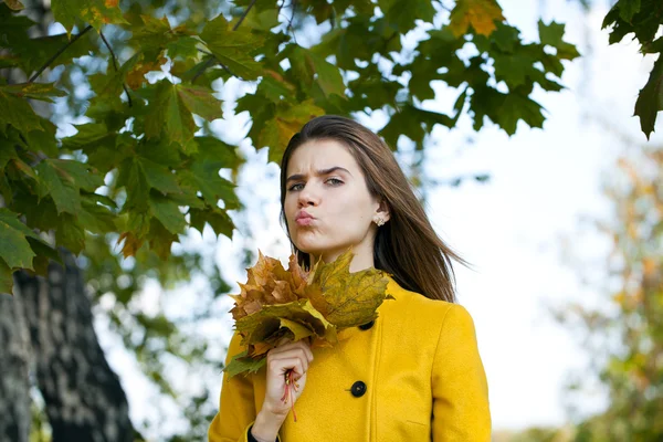Gelukkig jonge vrouw in gele jas in herfst park — Stockfoto