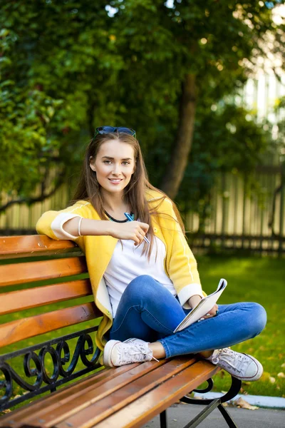 Belle jeune femme en manteau jaune — Photo