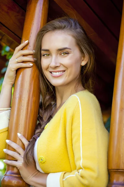 एक लाकडी घराच्या पोर्च वर उभे आनंदी तरुण स्त्री — स्टॉक फोटो, इमेज