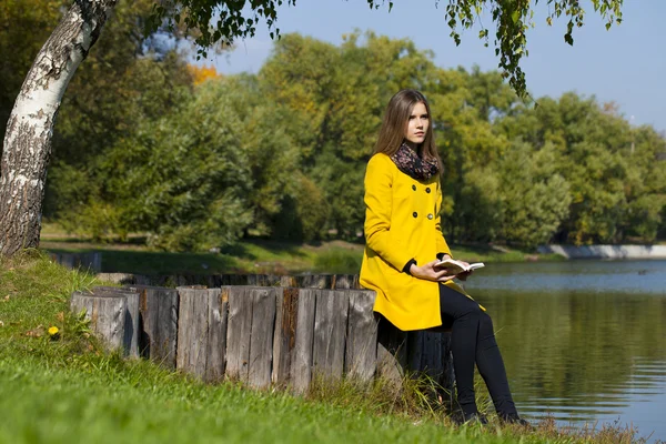 Bella giovane donna in cappotto giallo — Foto Stock