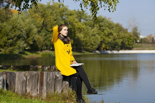 Bella giovane donna in cappotto giallo — Foto Stock