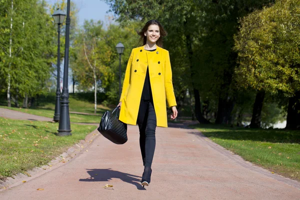 Mujer joven feliz en abrigo amarillo en la calle de otoño —  Fotos de Stock