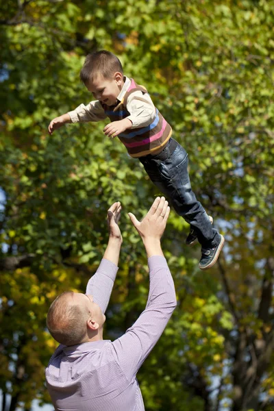 Mały chłopiec i ojciec w parku jesień — Zdjęcie stockowe