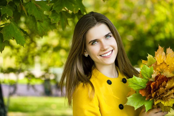 가 공원에 노란색 코트에서 행복 한 젊은 여자 — 스톡 사진