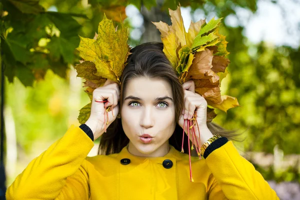 Joyeux jeune femme en manteau jaune dans le parc d'automne — Photo