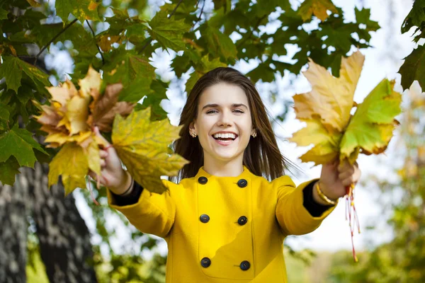 Joyeux jeune femme en manteau jaune dans le parc d'automne — Photo