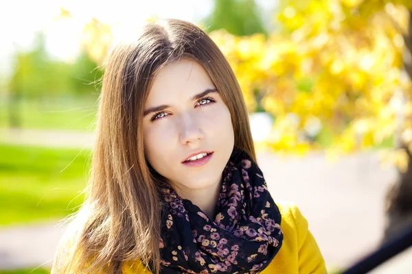 Glückliche junge Frau in gelbem Mantel in der Herbststraße — Stockfoto